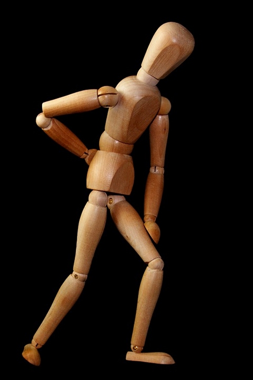 omino di legno con mano sulla schiena
