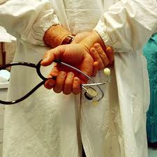 medico di spalle con stetoscopio in mano