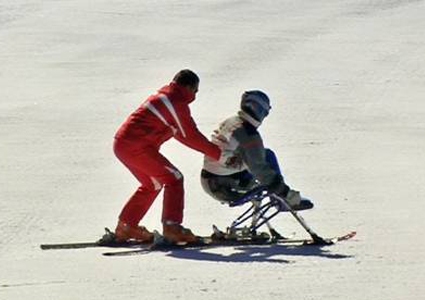 sciatore disabile che usa modalità sitting col suo insegnante