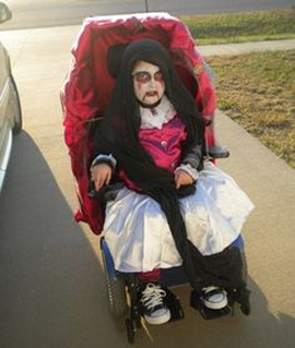 bambina in carrozzina vestita da strega