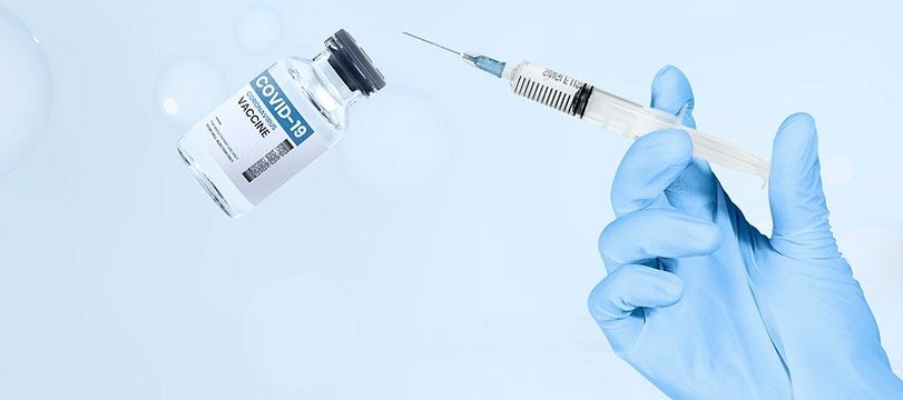 mano di un sanitario con siringa e boccetta di vaccino anti covid