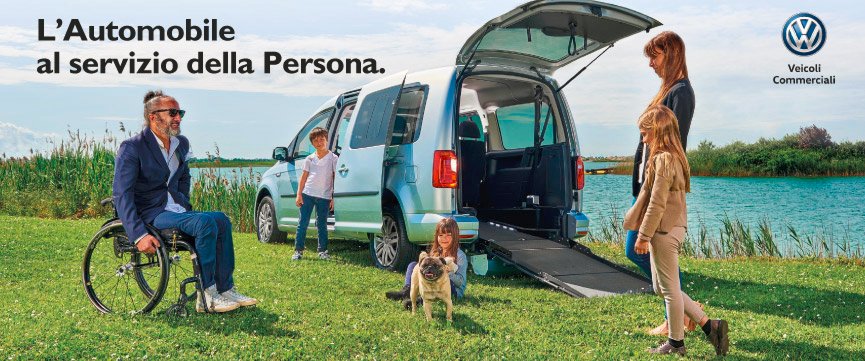 auto Volkswagen con bagagliaio aperto e pianale ribassato con famiglia e un genitore in carrozzina